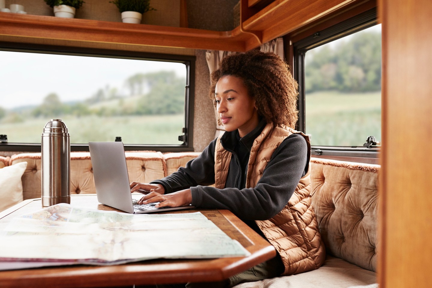 Young woman using laptop while sitting in camper van.