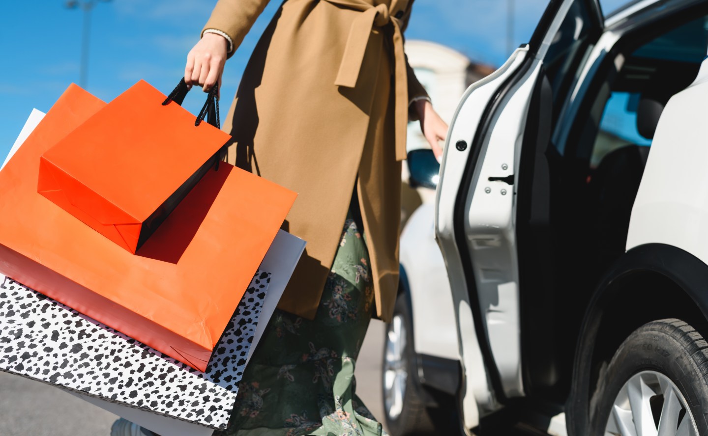 A woman loads shopping bags into her car