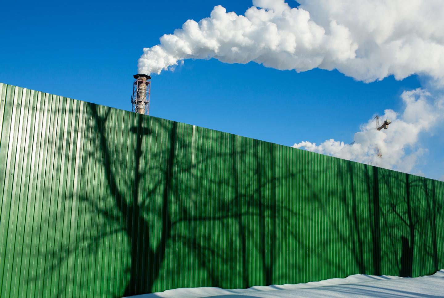 Green fence in front of chimneys.