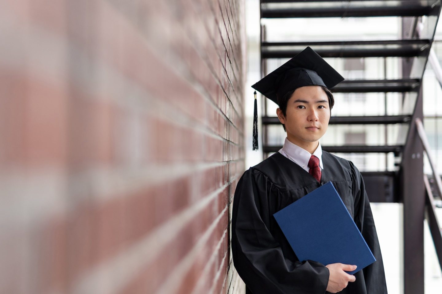 man in cap and gown holding diploma