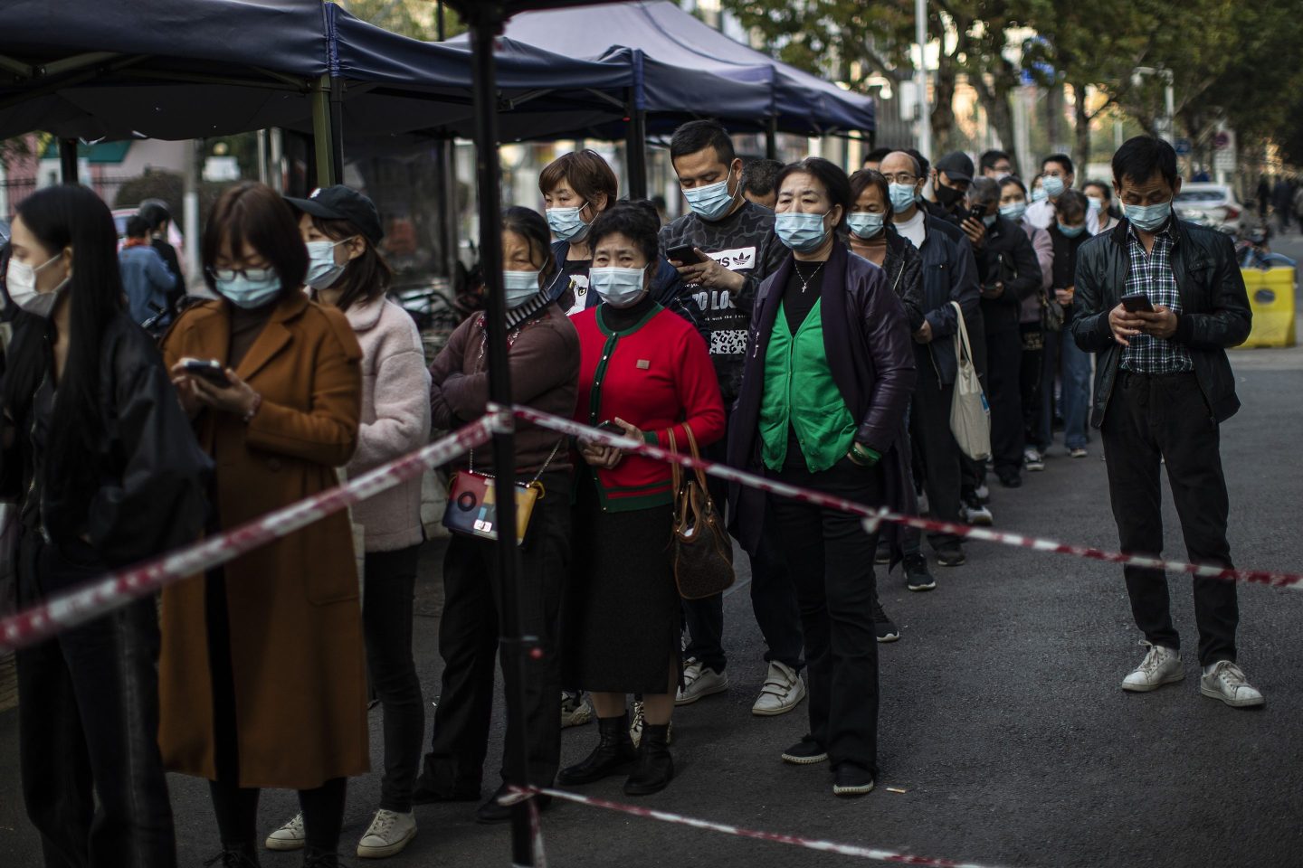 Residents wear masks while lining up to receive COVID-19 vaccines at a vaccination site on November 18, 2021 in Wuhan, China.