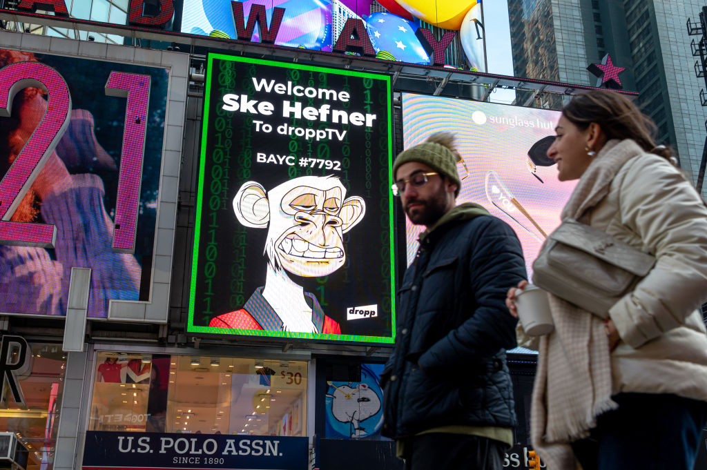People walk by a Bored Ape Yacht Club NFT billboard in Times Square on January 25, 2022 in New York City.