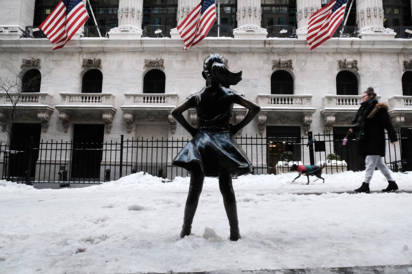 People walk by the Fearless Girl statue in New York City