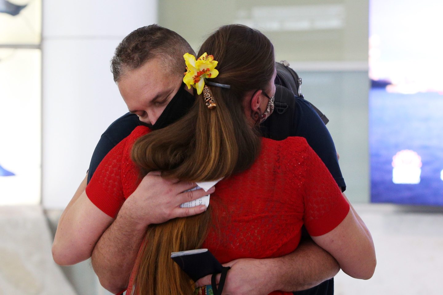 A man and a woman embrace at Sydney Airport