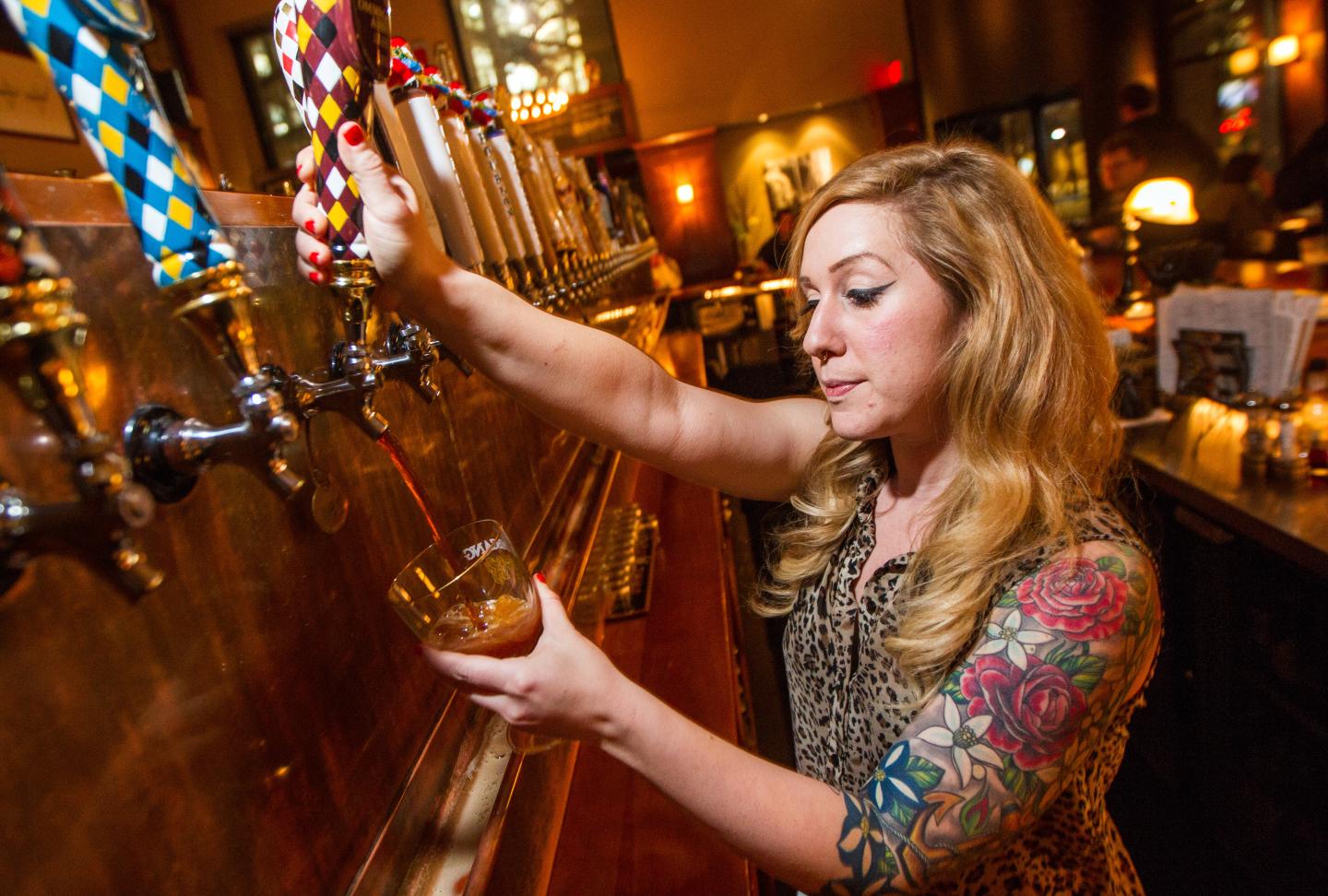 Female bartender pouring beer