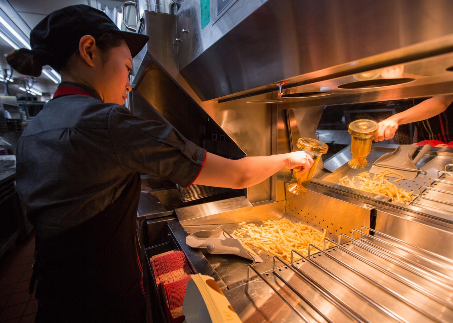 McDonald's worker adds salt to french fries