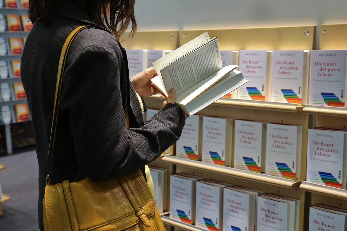 A visitor reads books at a stand the 2017 Frankfurt Book Fair
