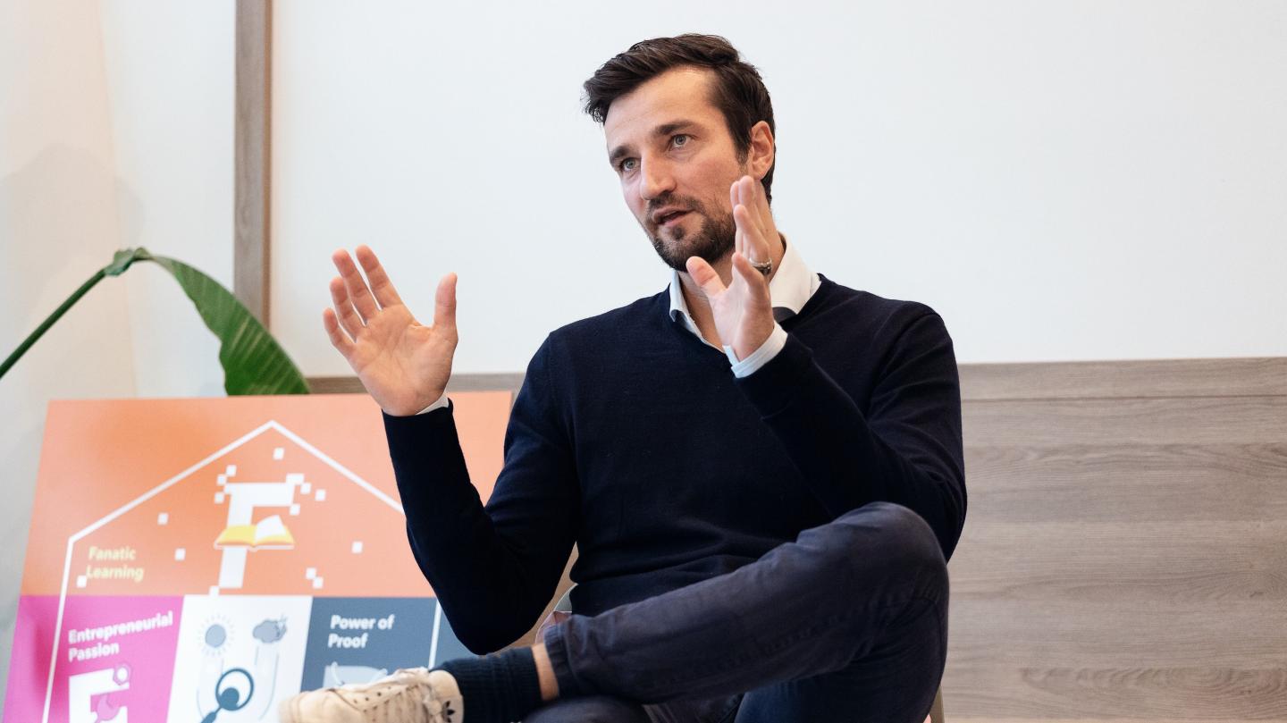 Trivago CFO Matthias Tillmann sits on stage giving a presentation