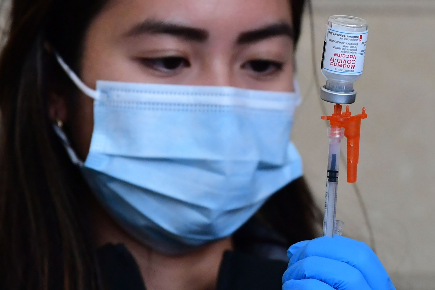 A health care worker prepares a dose of Moderna COVID-19 vaccine