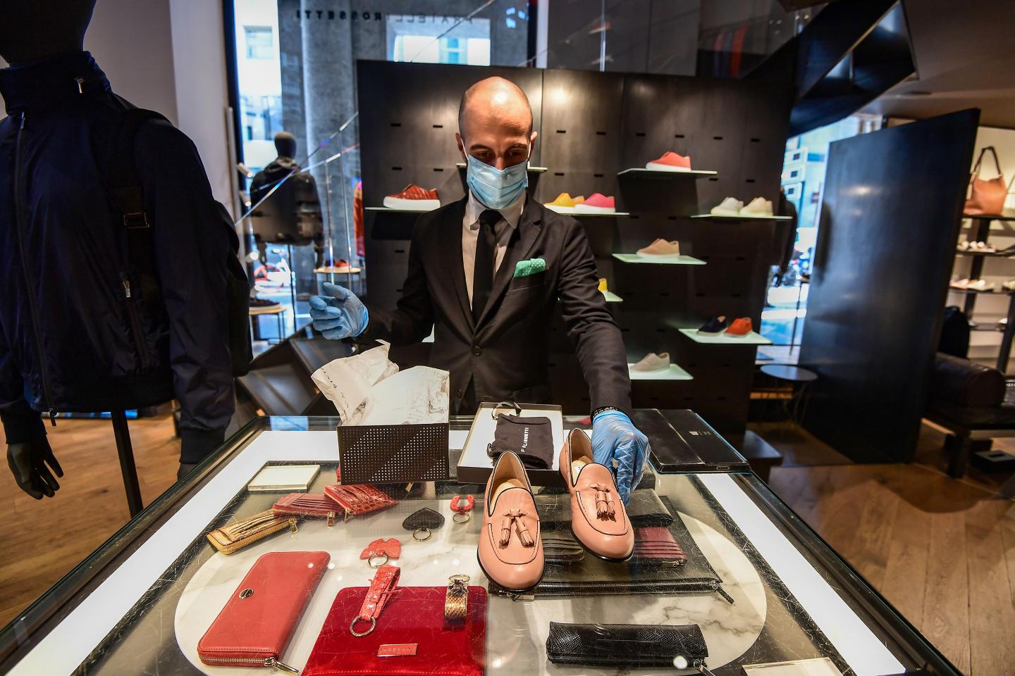 A seller puts items at a Fratelli Rossetti fashion shop in Milan.