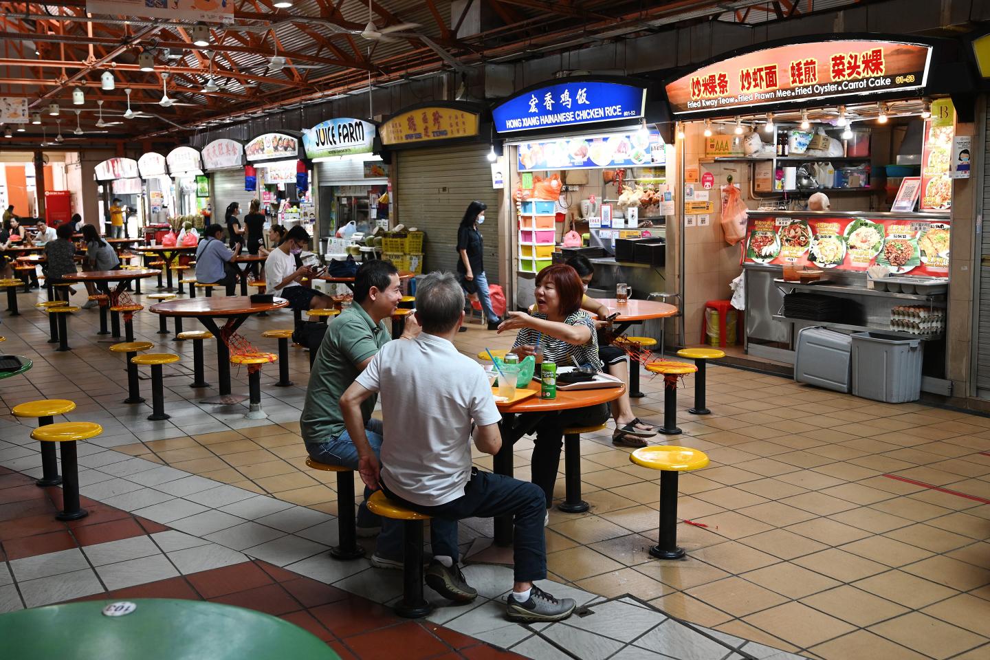 People have their lunch at the Maxwell market hawker centre in Singapore.