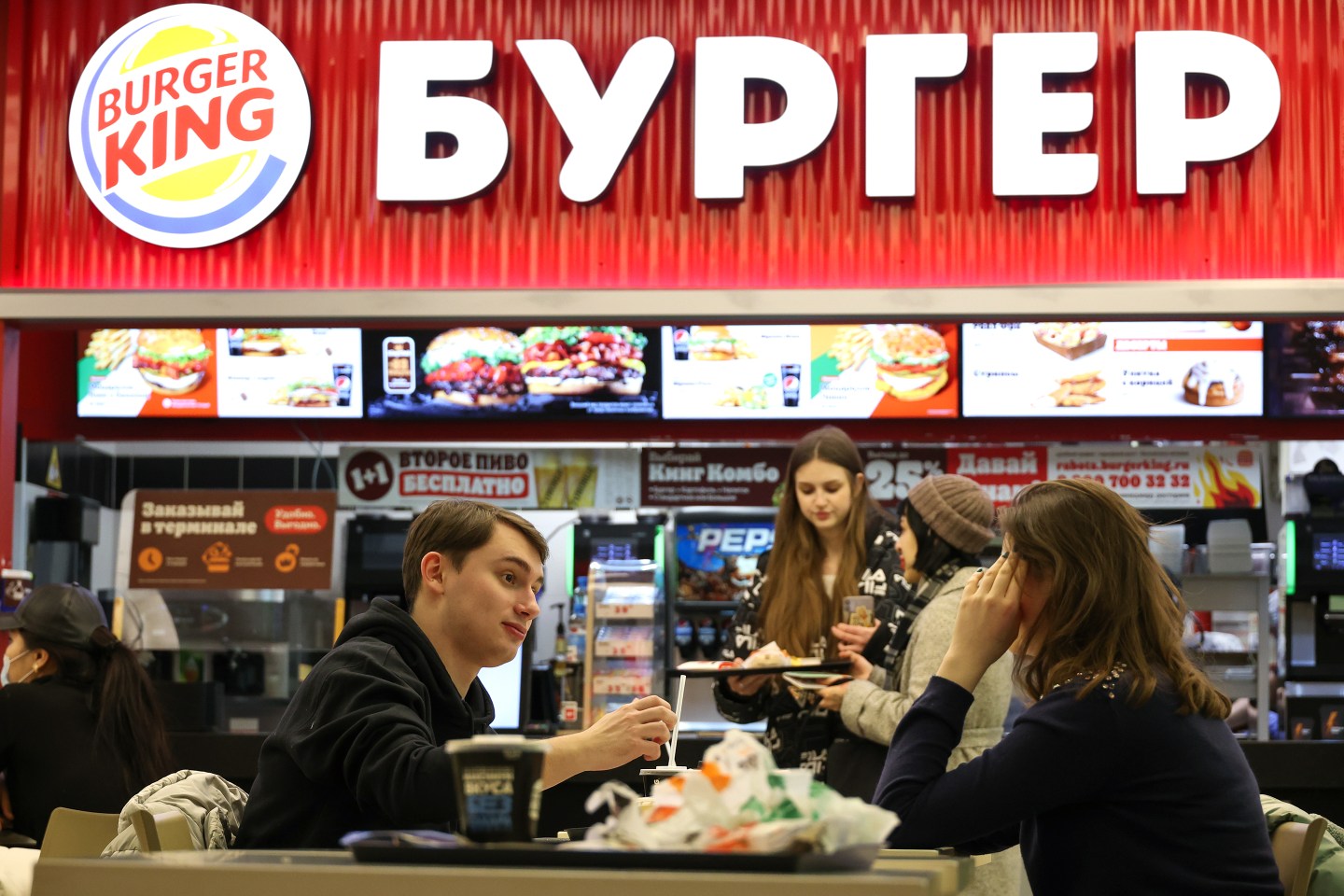 People eat at Burger King in the Okhotny Ryad shopping center.