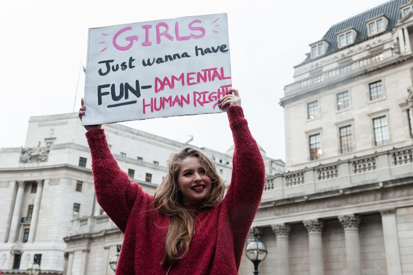 A woman in London holds a sign protesting women’s lack of equal rights