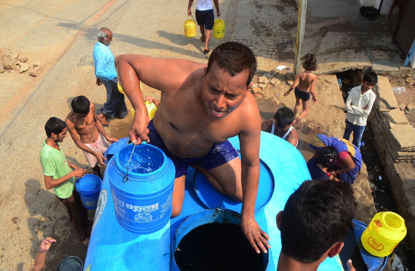 People gathering water from a water truck in India.