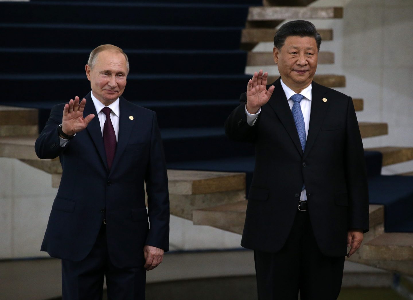 Russian President Vladimir Putin (L) and Chinese President Xi Jinping (R) wave during a welcoming ceremony on November 14, 2019 in Brasilia, Brazil.