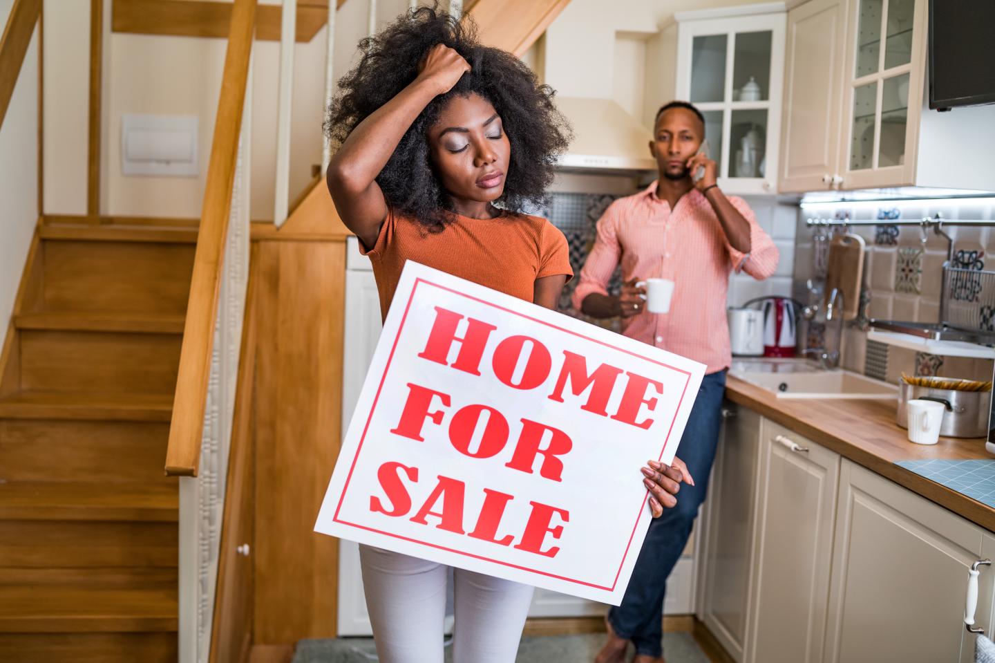 Couple with “home for sale” sign