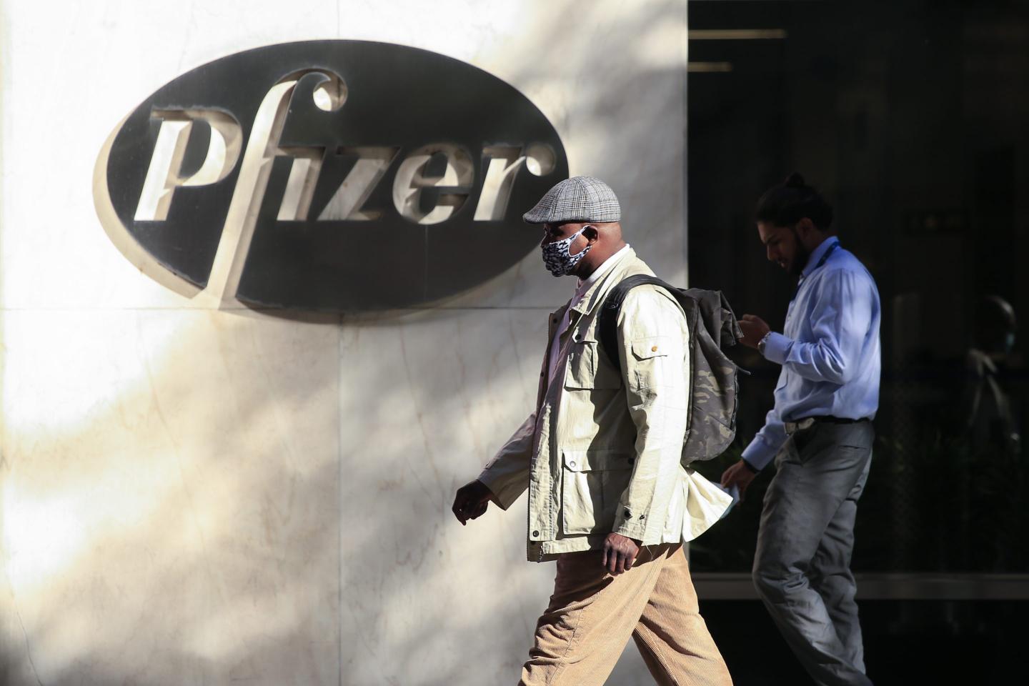 People walk by Pfizer building in NYC
