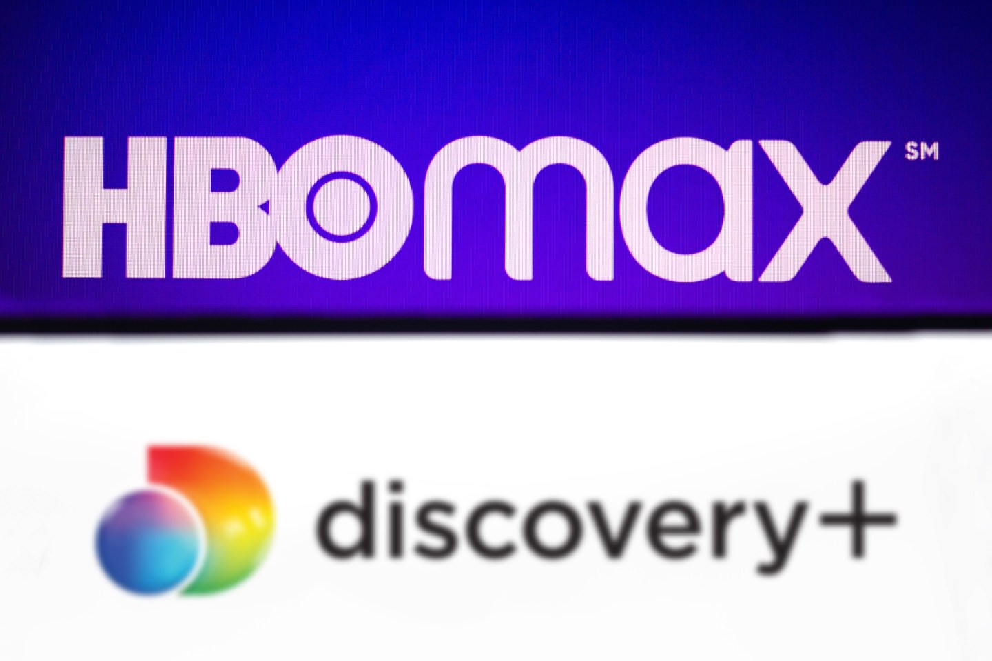 The logos of HBO Max and Discovery Plus.