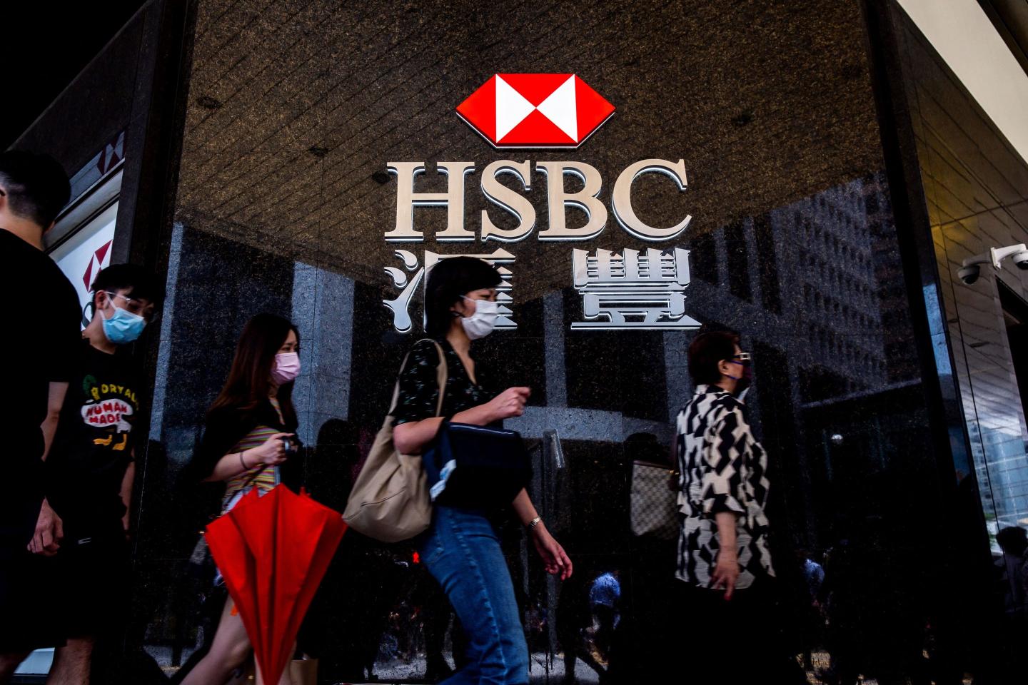 Pedestrians walk past an HSBC branch bank in Hong Kong