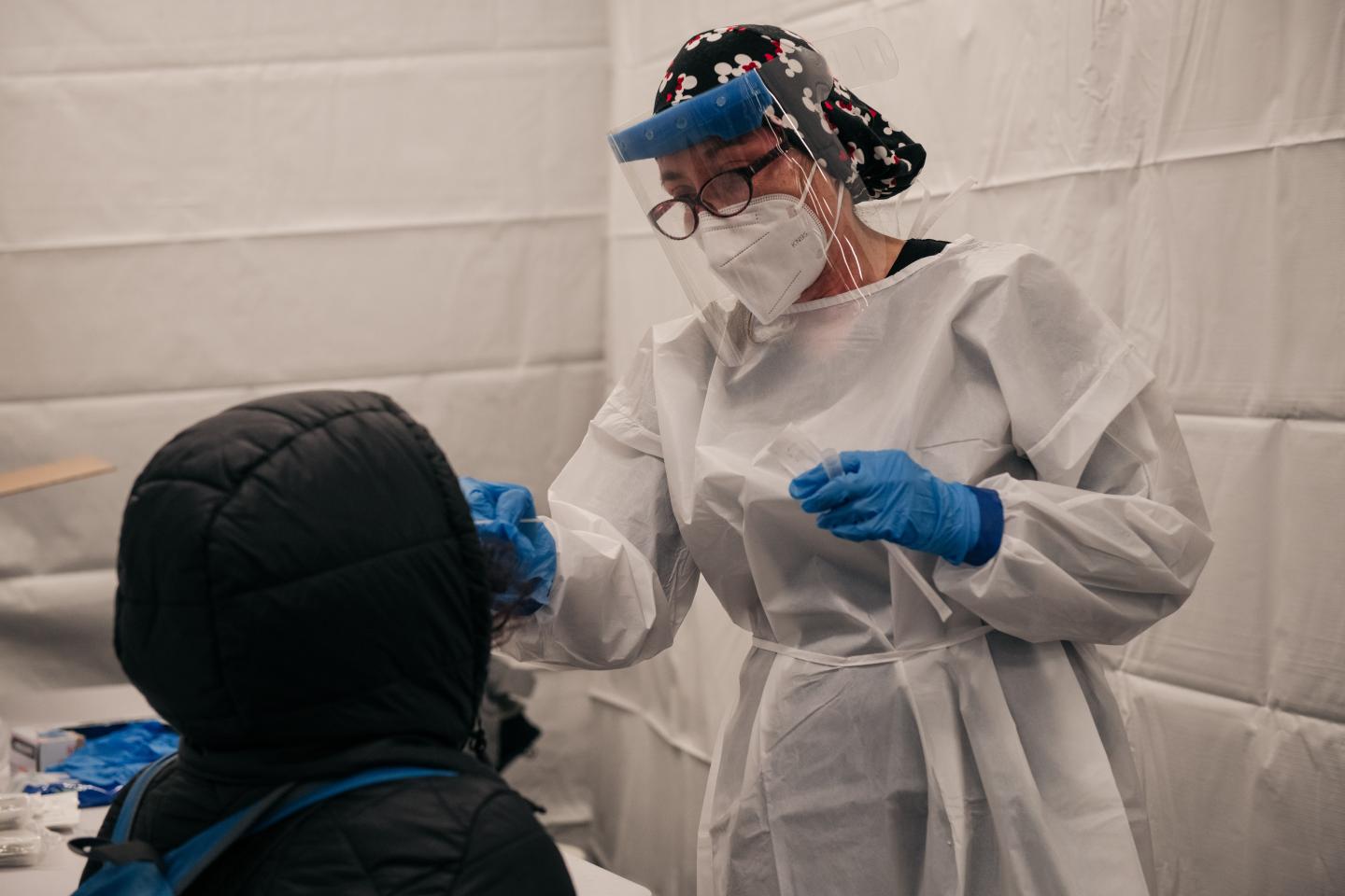A medical worker administering a COVID test.