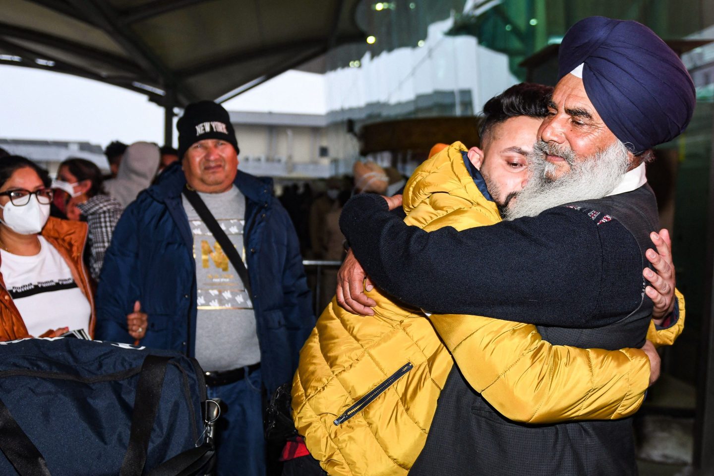 A passenger is greeted by his relative at Sri Guru Ram Dass Jee International Airport on January 6, 2022.