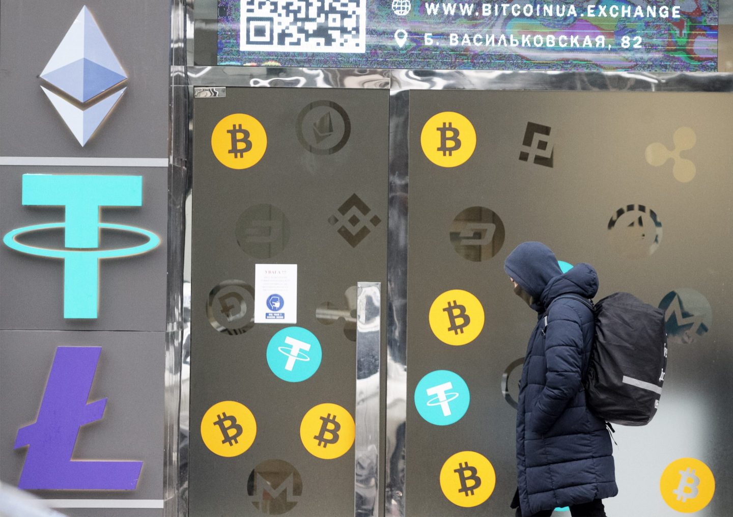 Man walking past cryptocurrency exchange