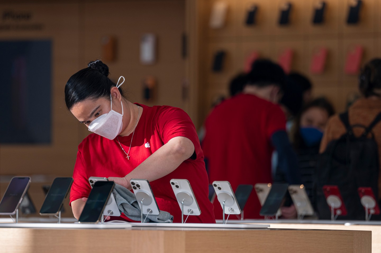 Apple store employee checks iPhones