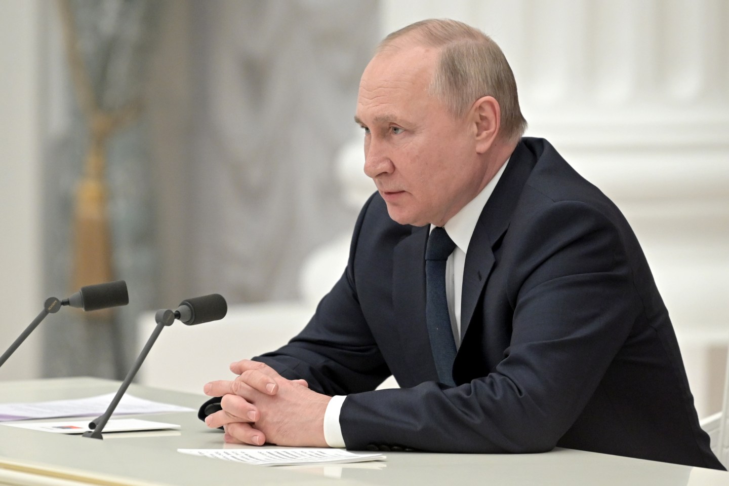 Russian President Vladimir Putin sits at a desk