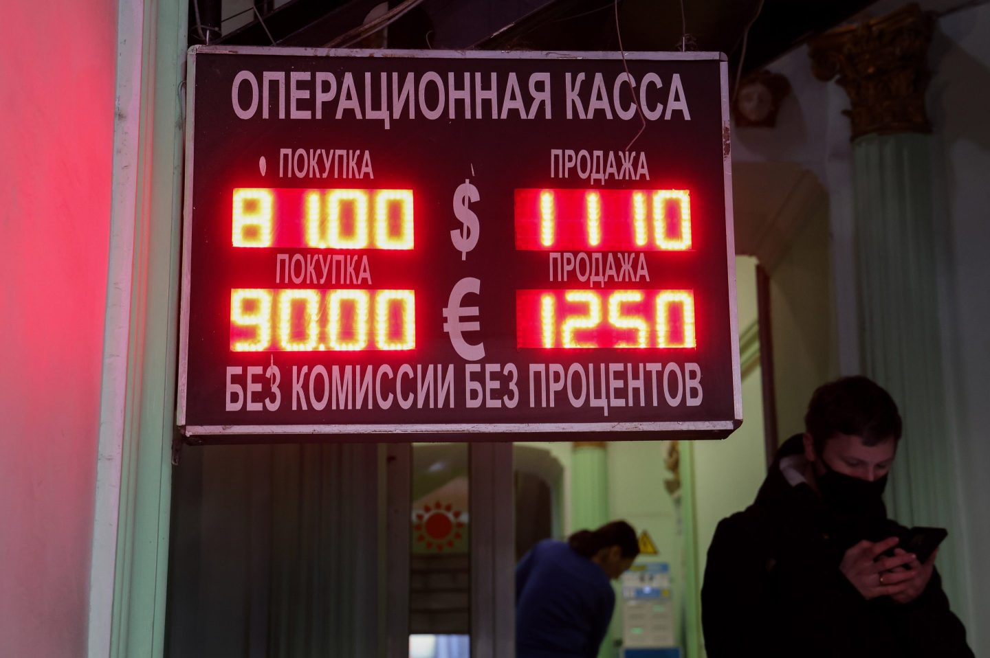 A board showing exchange rates between the Russian ruble, the U.S. dollar, and the euro