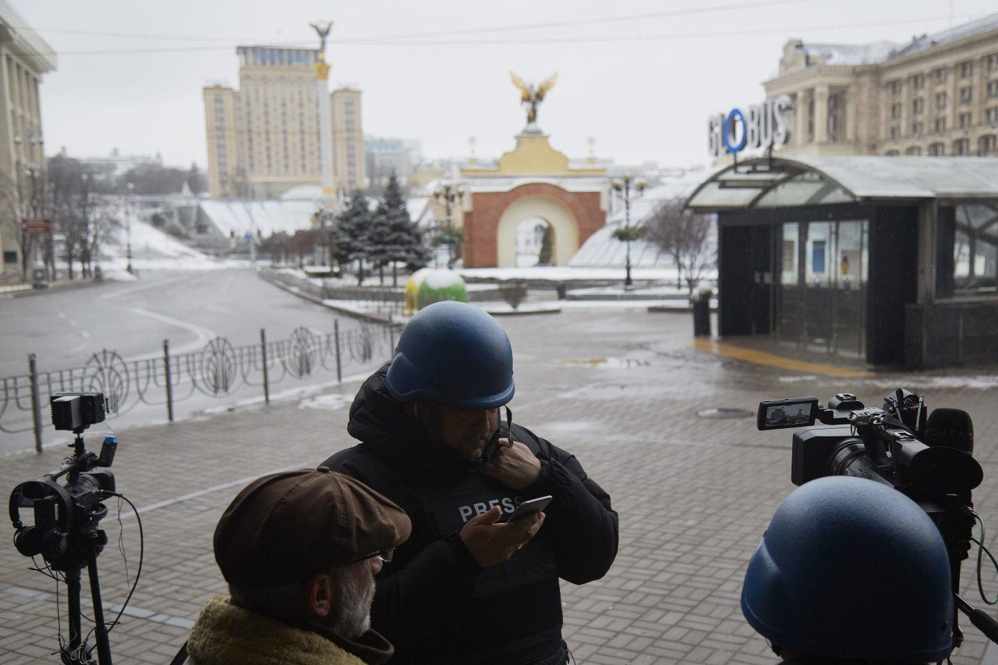 Journalists are seen working on the doorstep of a hotel in Ukraine.