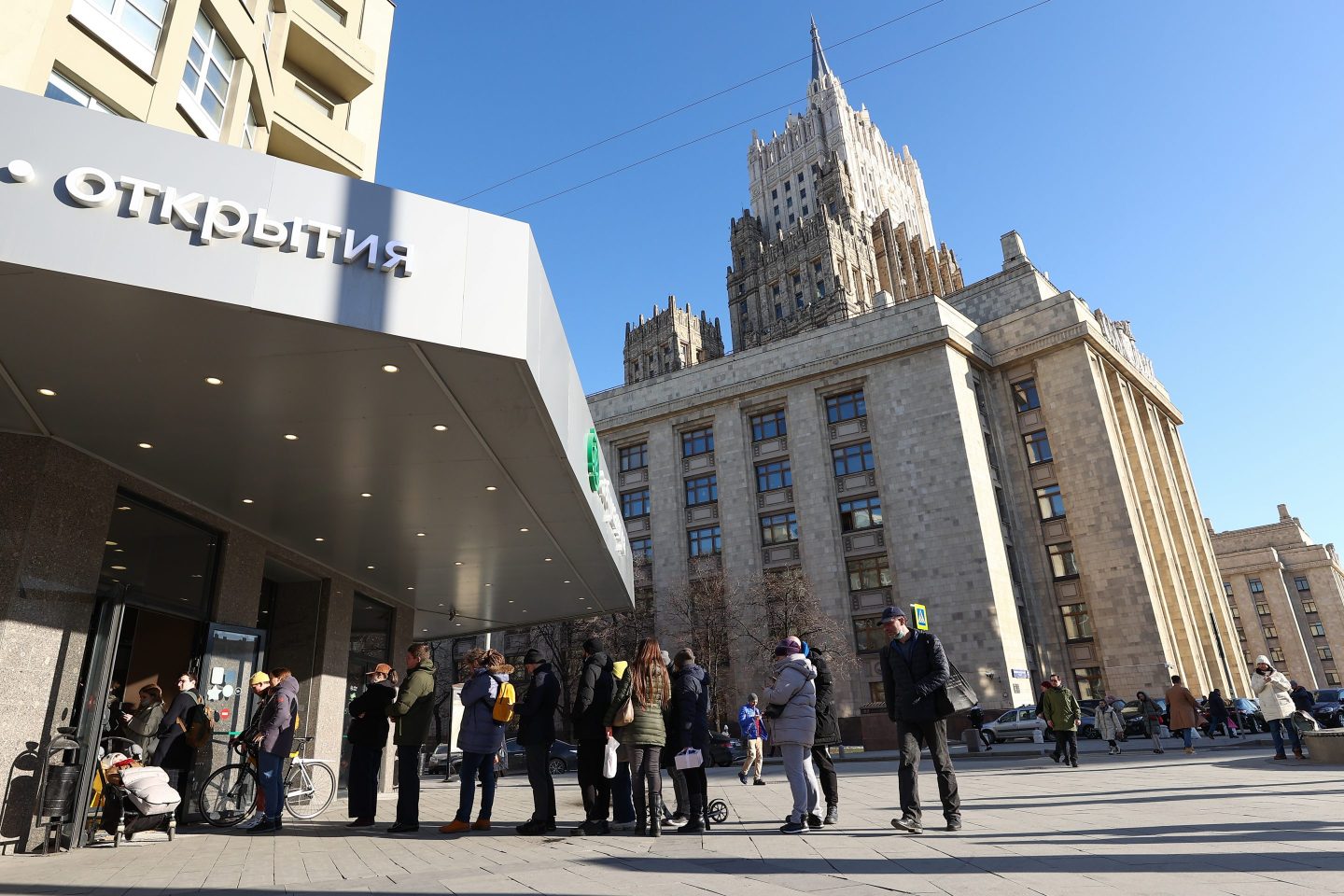 People queue by a Tinkoff Bank ATM machine in central Moscow