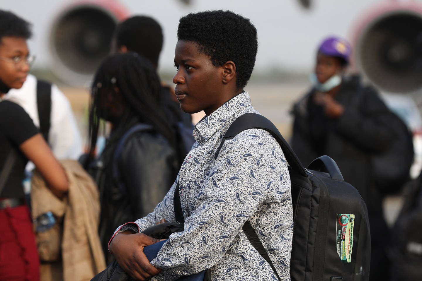 A young Nigerian student wearing backpack waits after landing in Nigeria from Ukraine