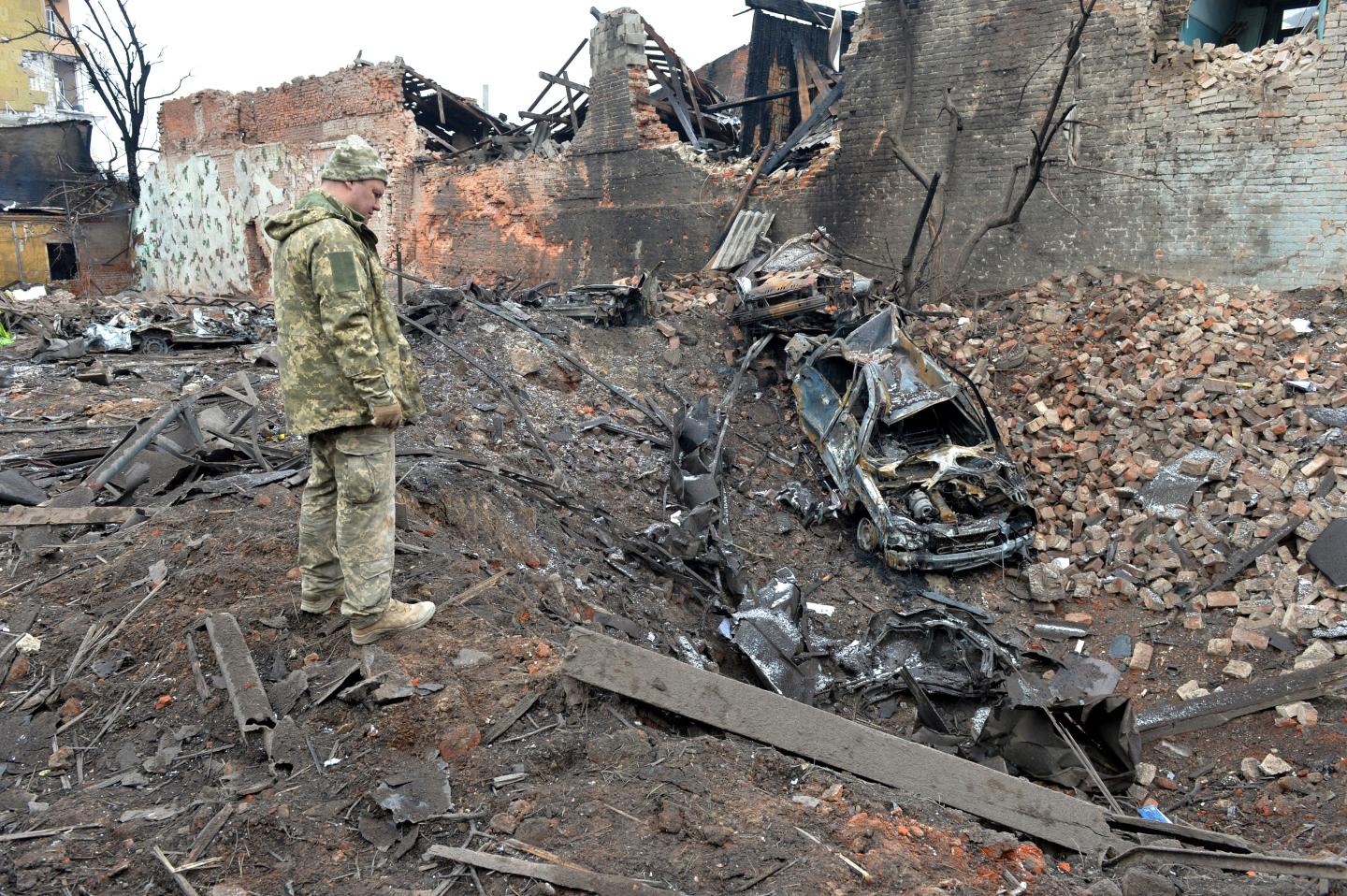 A Ukrainian serviceman looks at destructions following a shelling in Ukraine's second-biggest city of Kharkiv on March 7, 2022.