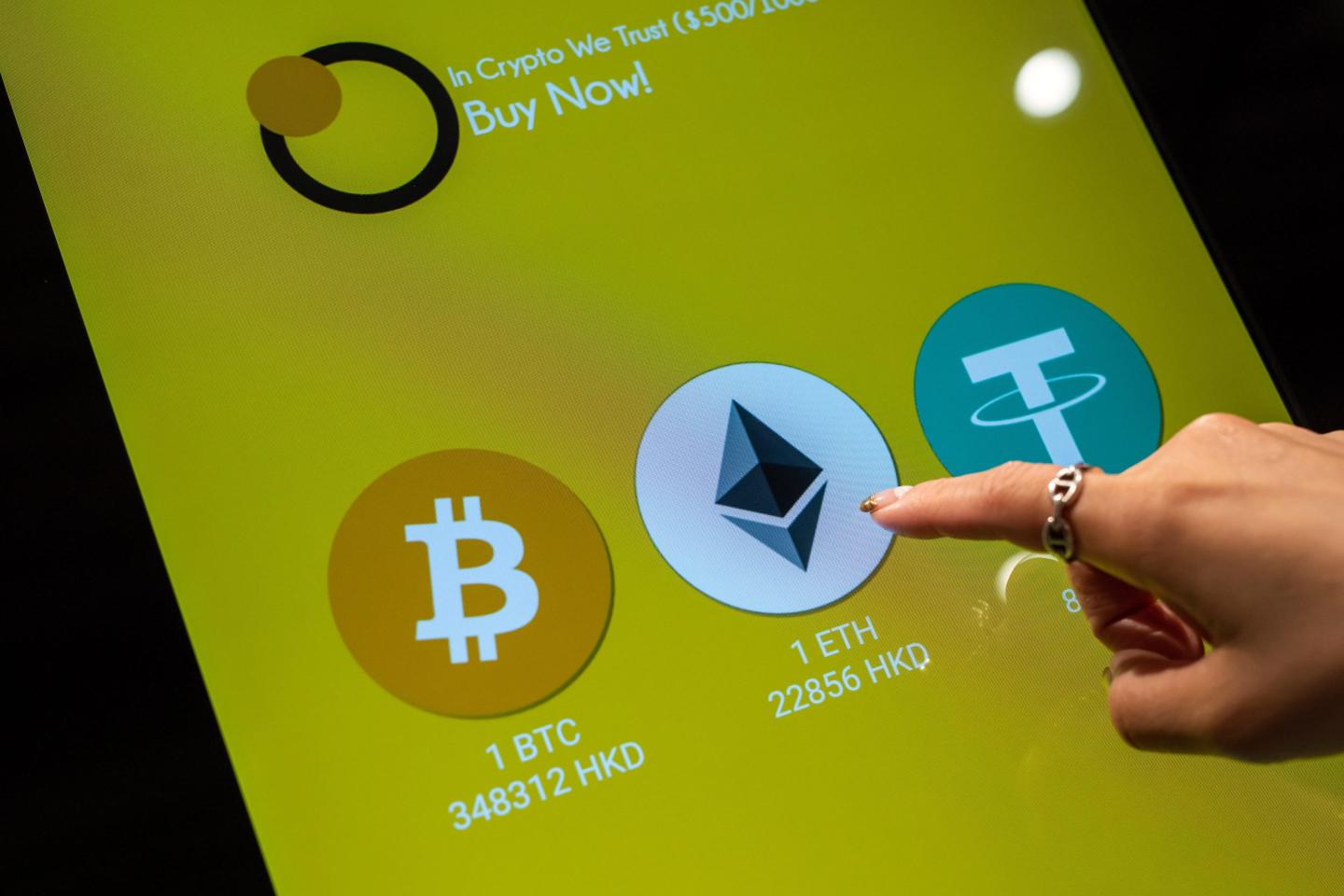 A finger hovers over an Ethereum icon on screen