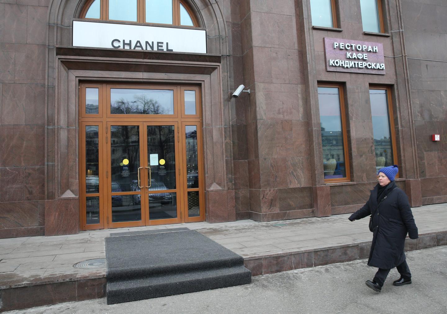 A Russian woman walks in front of a closed Chanel store