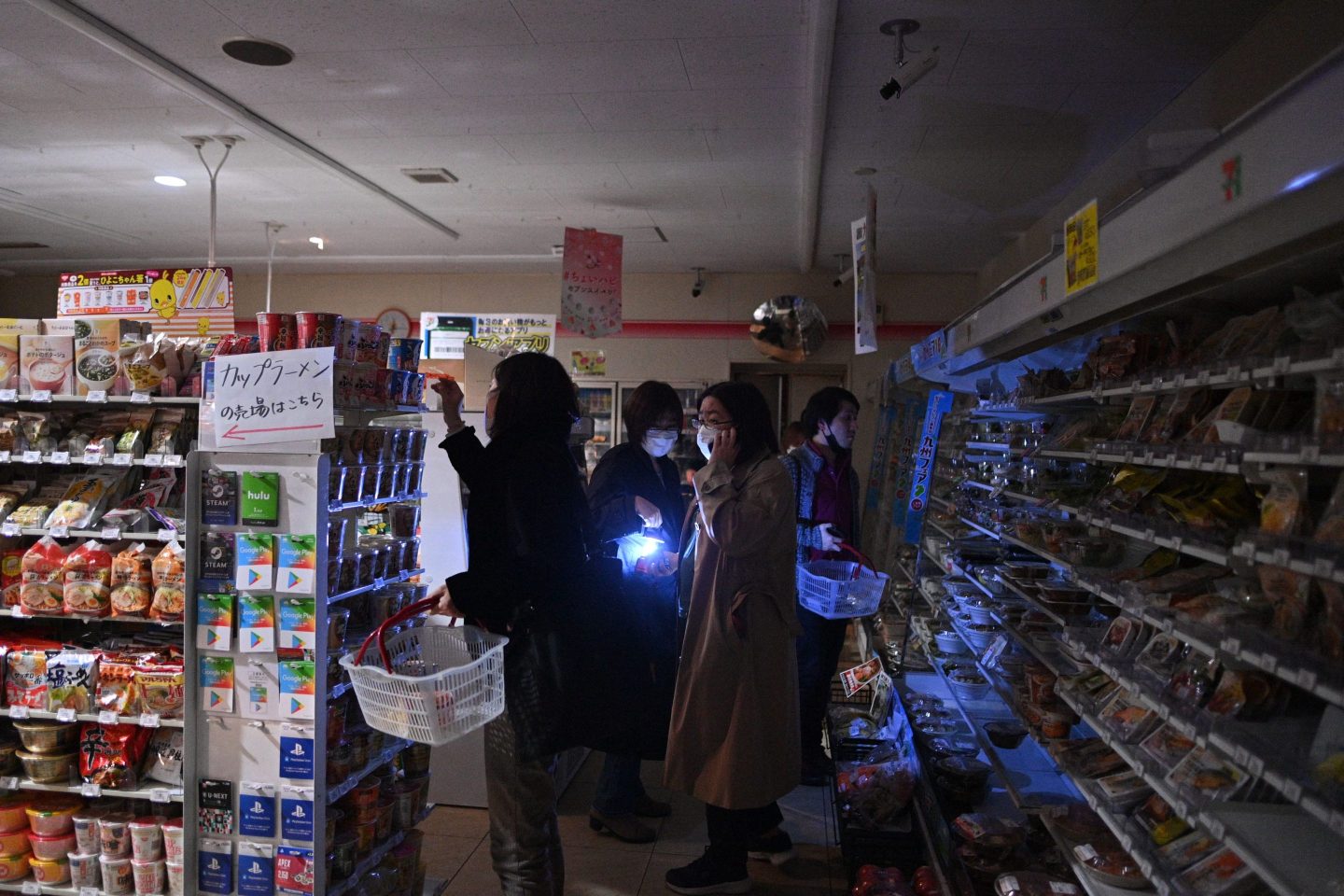 People shop in a store during a power outage.