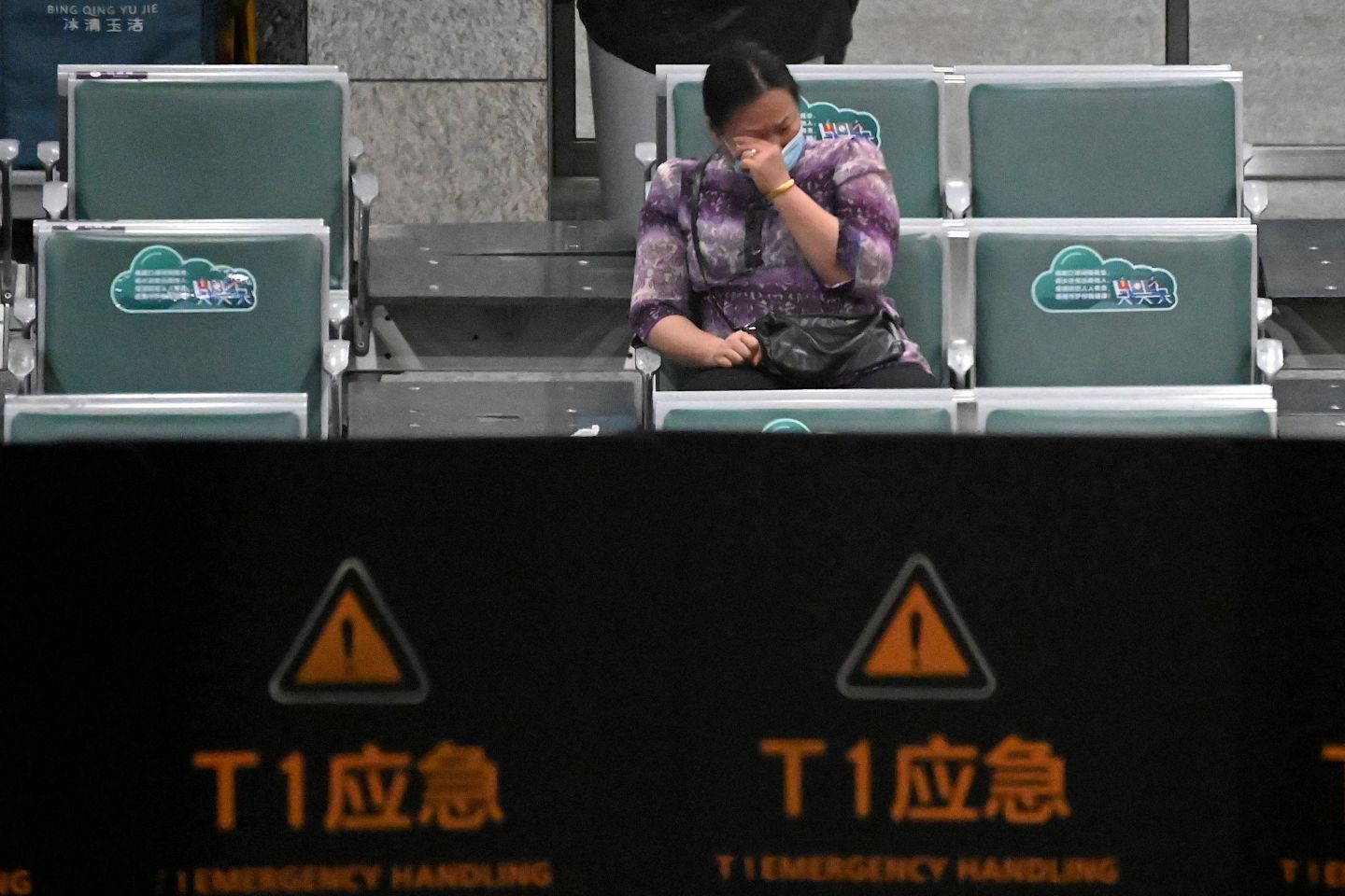 A relative of one of the victims of the Flight MU5735 crash sits alone in Guangzhou airport, crying