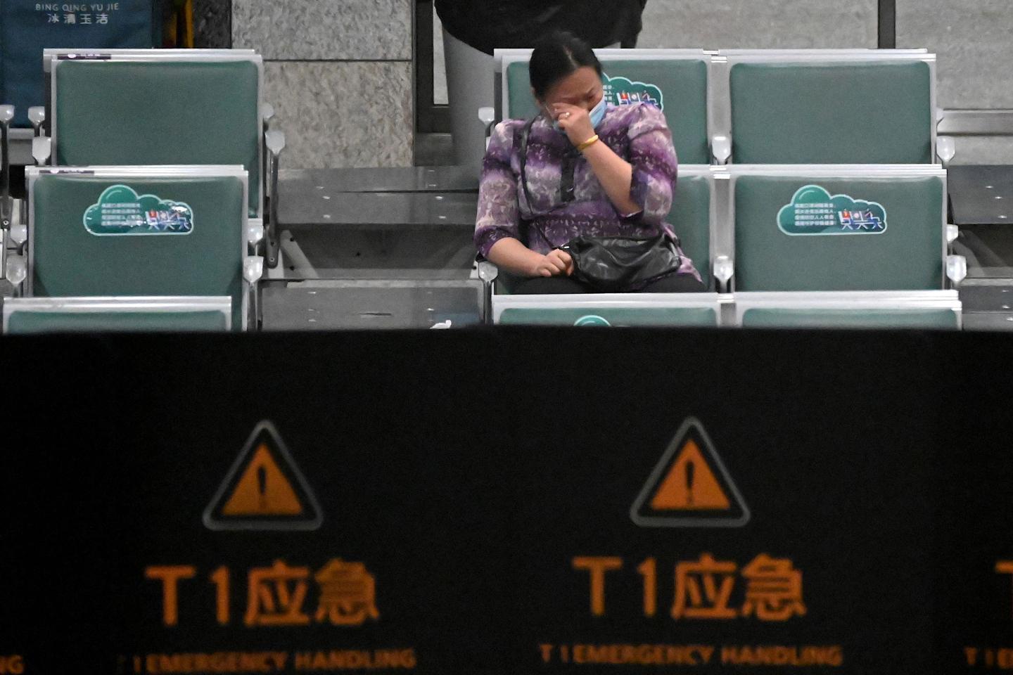 A relative of one of the victims of the Flight MU5735 crash sits alone in Guangzhou airport, crying