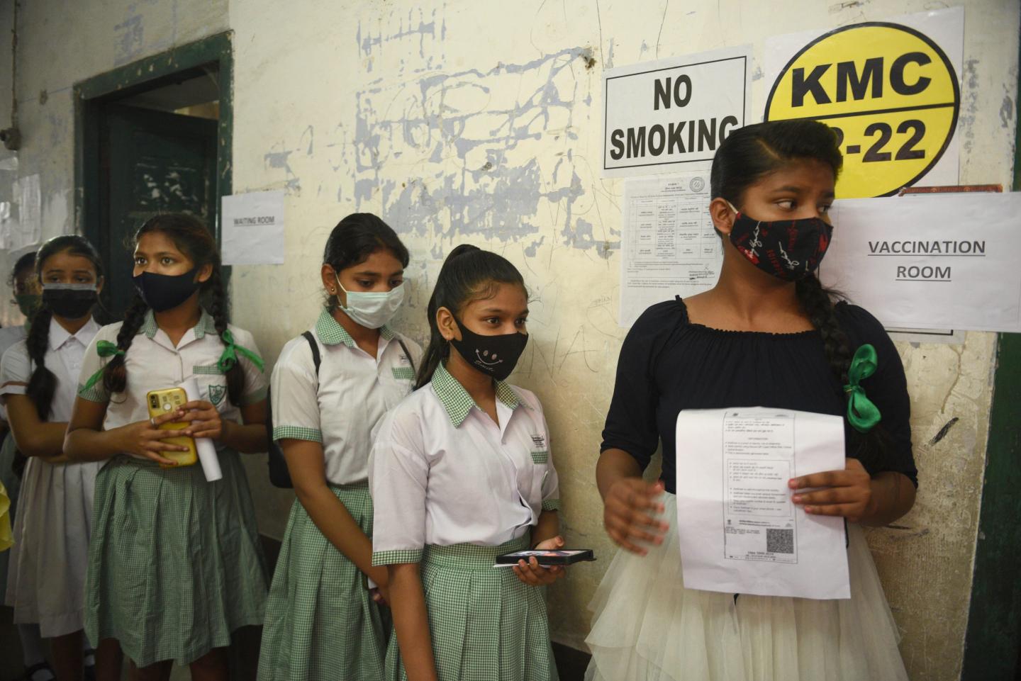 Indian students wait in line for a COVID vaccine