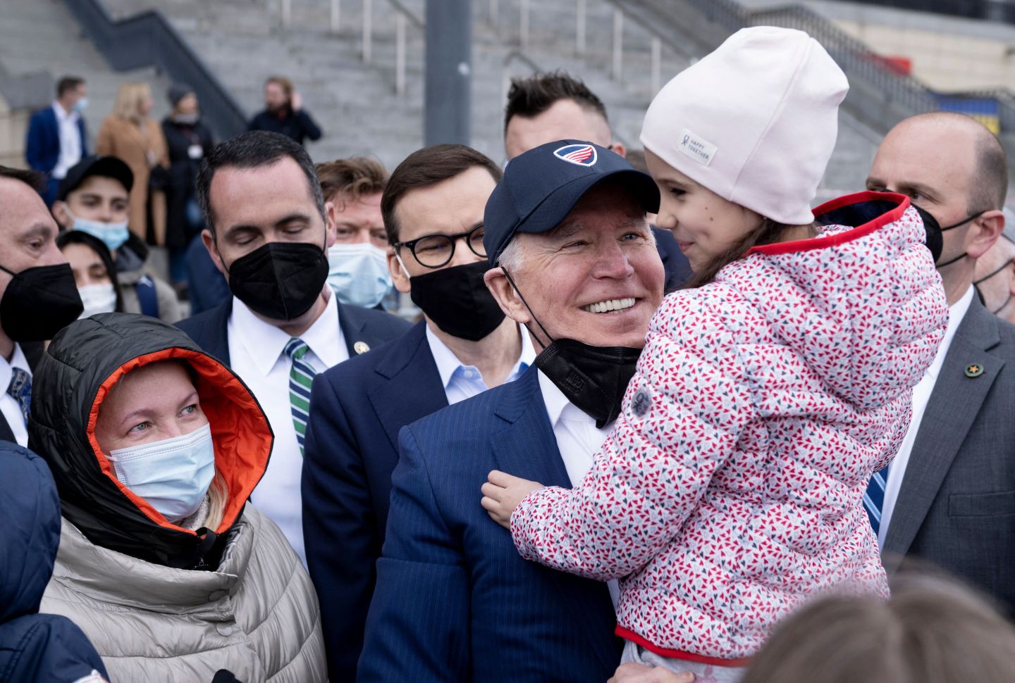 U.S. President Joe Biden holds a girl on his arm as he and Polish Prime Minister Mateusz Morawiecki meet with Ukrainian refugees at PGE Narodowy Stadium in Warsaw on March 26.