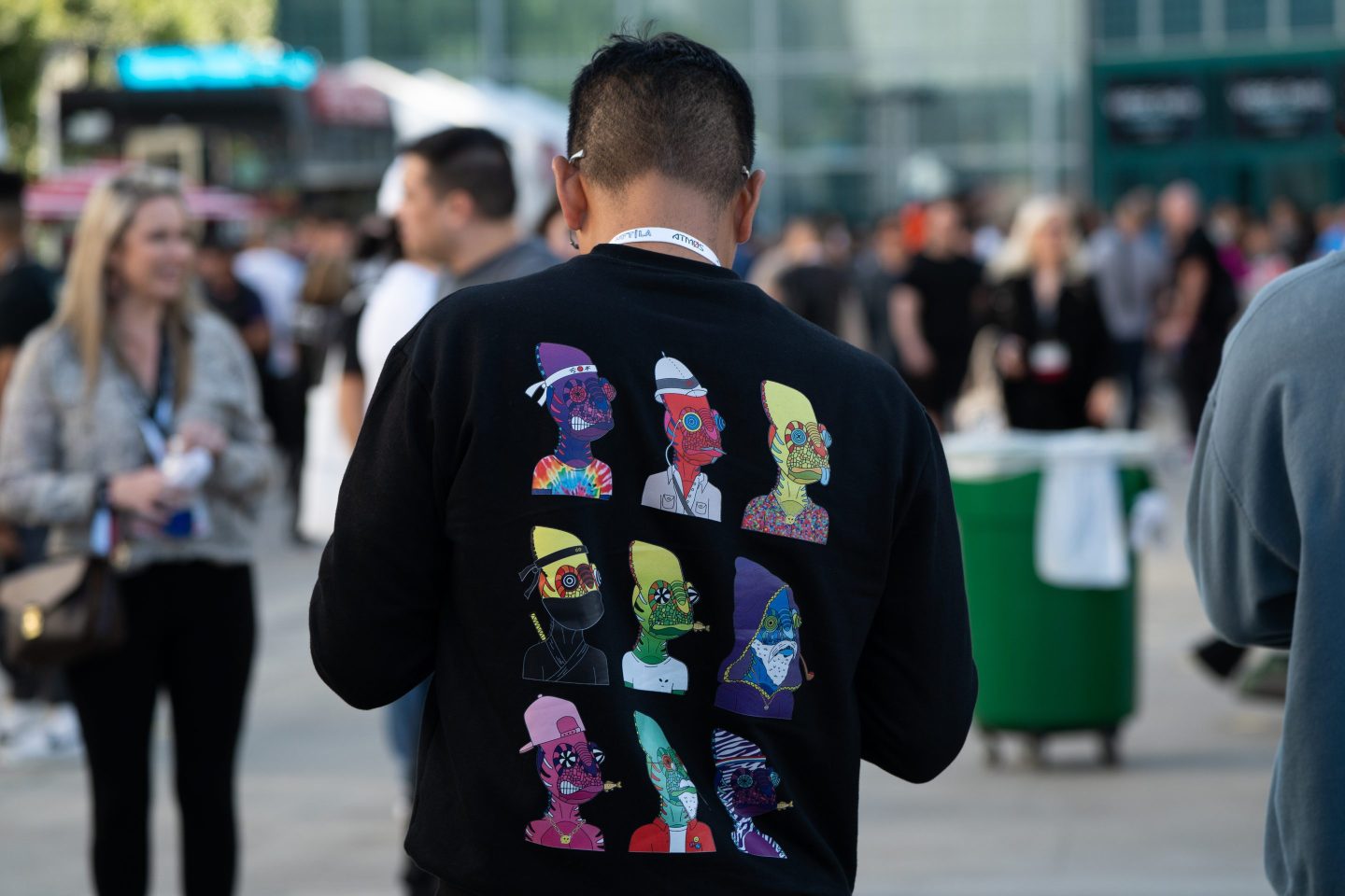 Person wearing sweatshirt with NFT art on it.