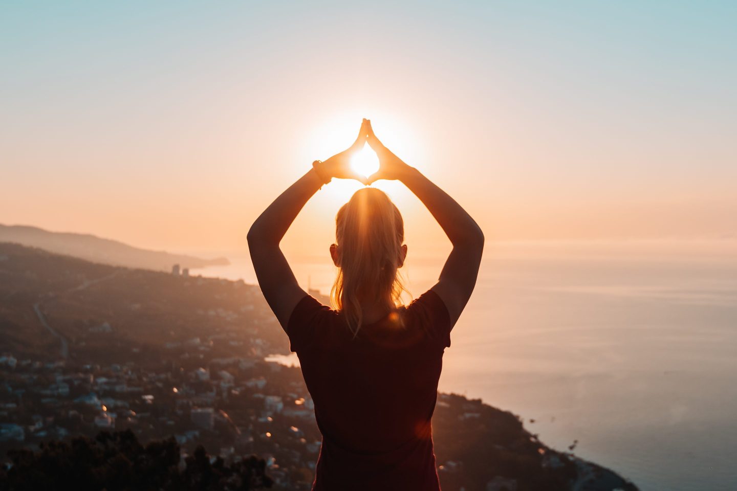 Silhouette of woman doing yoga at sunrise