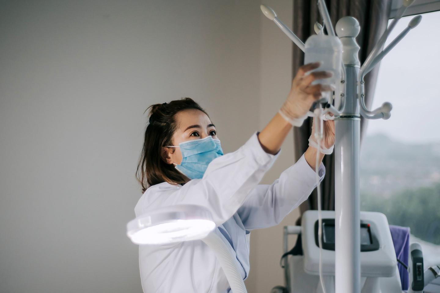 Female nurse holds and adjust saline injection