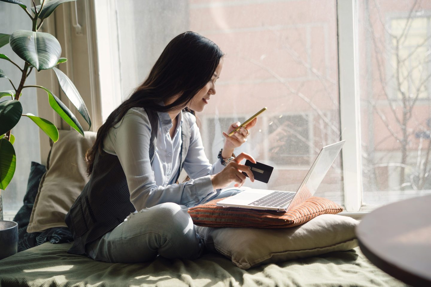 Woman makes a purchase on her smartphone with a credit card.