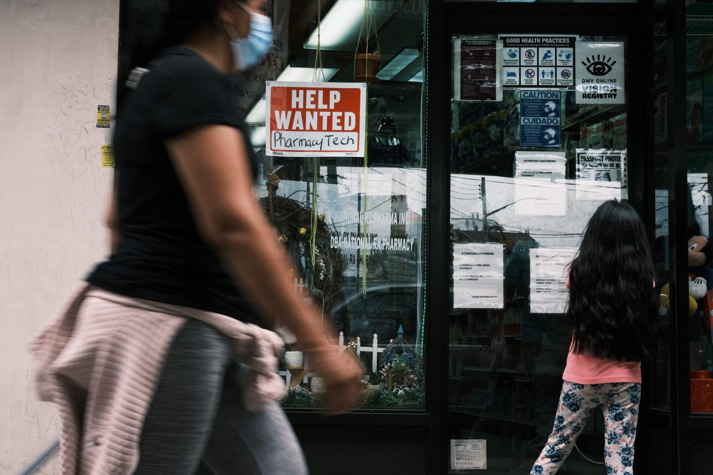 Woman walks by hiring sign in Queens, New York