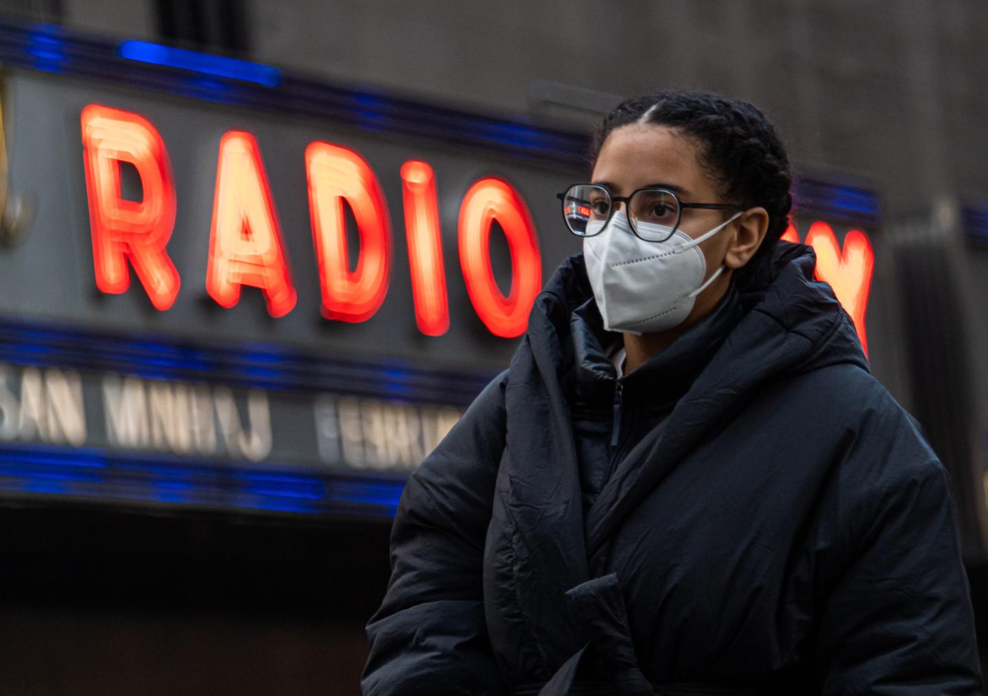 Woman walks outside Radio City Music Hall in NYC