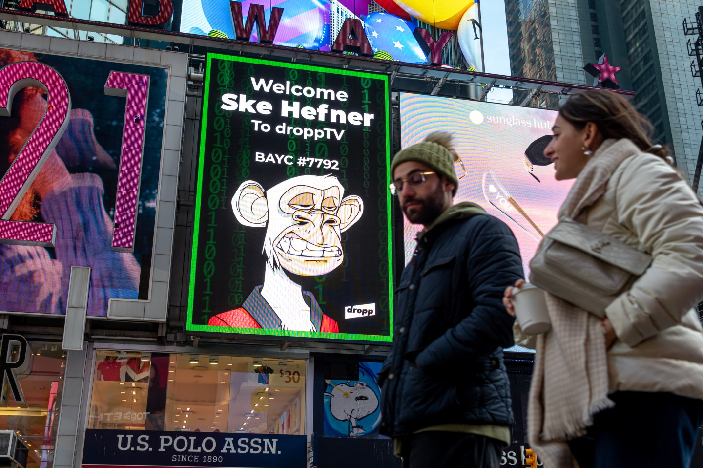 People walk by a Bored Ape Yacht Club NFT billboard in Times Square