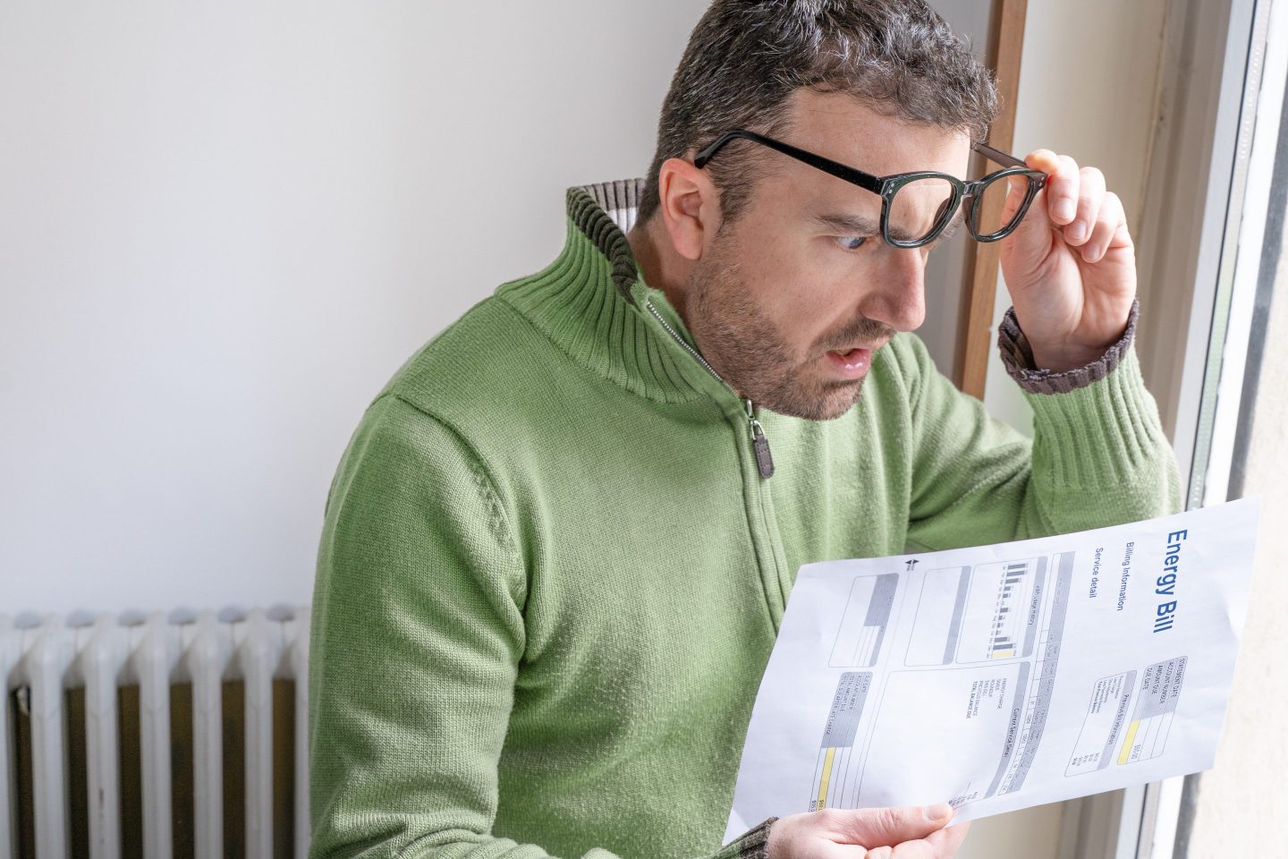 Man looking at his utility bill with dismay