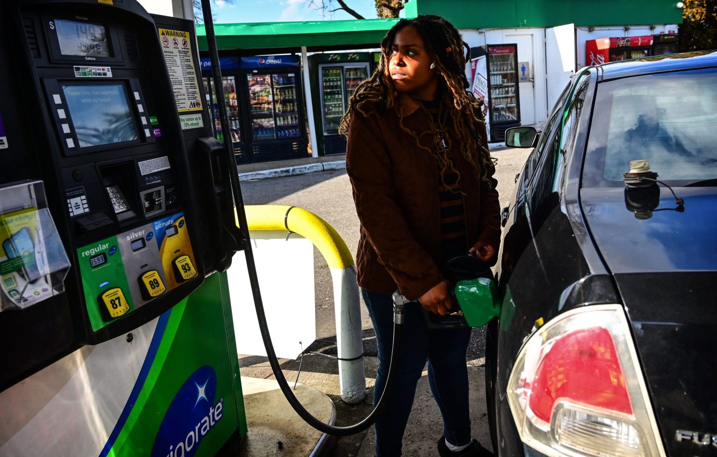 A woman fuels up her car at a gas station in Long Island, NY