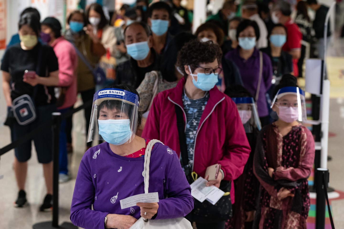 People wait in a queue to register to receive the Sinovac Covid-19 coronavirus vaccine at a vaccination center set up inside a train station on March 11 in Hong Kong, China.